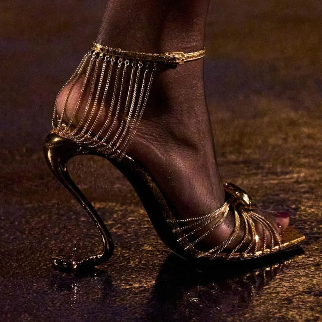 Saint Laurent convirtió el zapato en una de las piezas más comentadas de París Primavera:Verano 2027- sus sandalias doradas con tacón en forma de serpiente llevaron el accesorio del fondo del look directamente al centro de la conversación.