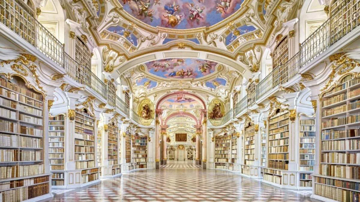 Interior de la Biblioteca de la Abadía de Admont en Austria, con estanterías de libros, techos decorados con frescos
